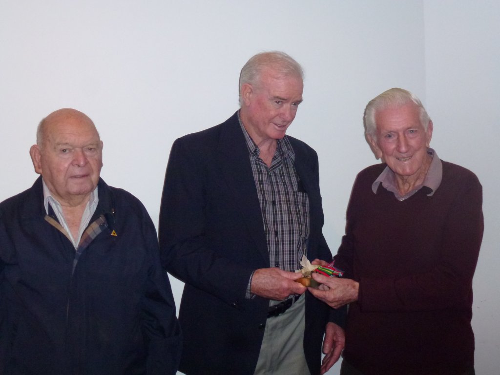 John Morrisey, youngest son of Bert Morrisey receives his father's medals from John Gilmour & Ron Badock.